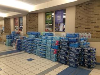 Cases of bottled water line the hallways of John Adams High School. Photo Credit/Gabriela Gil