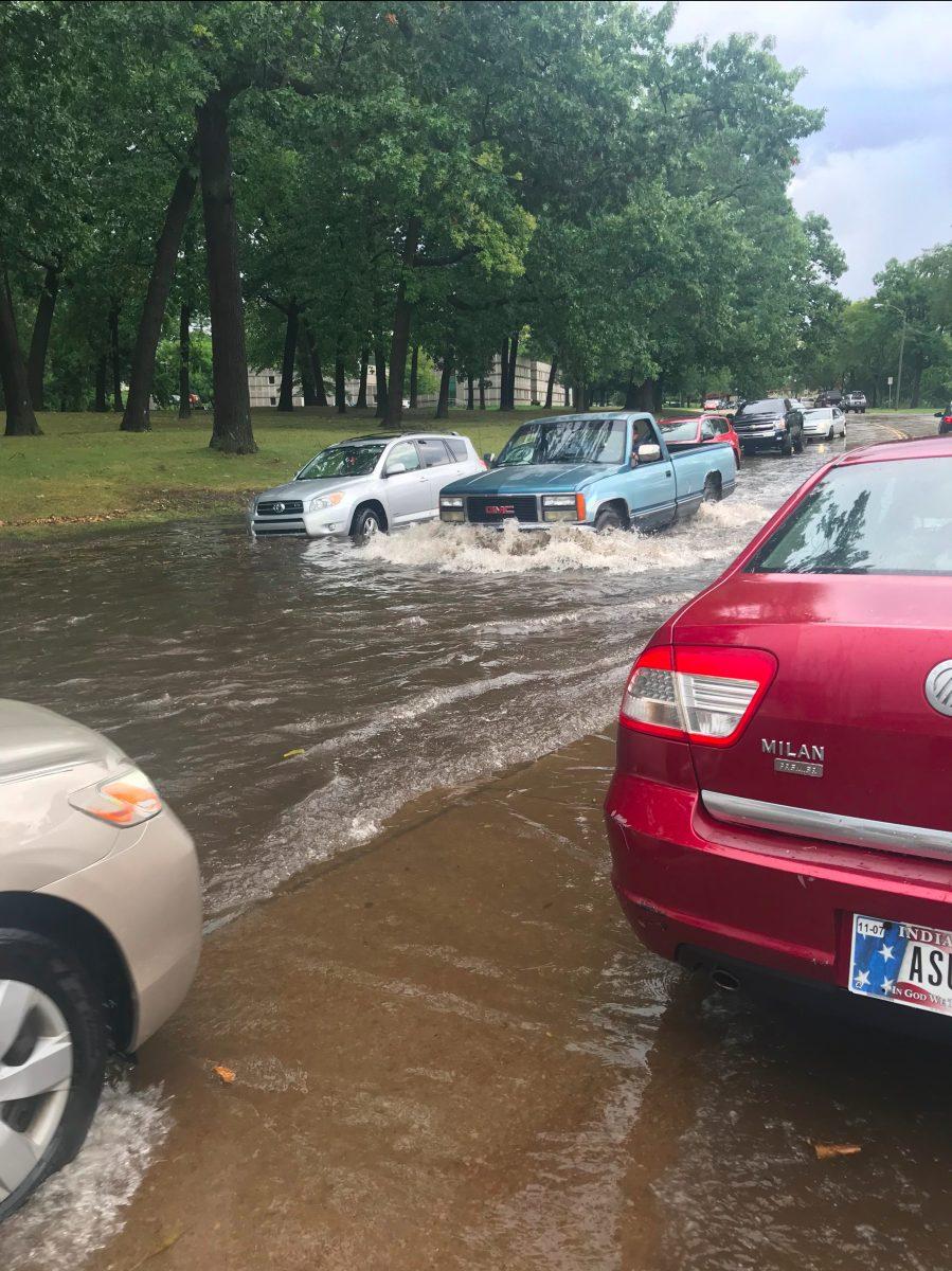 Cars sit in standing water on Northside Blvd., as others cautiously drive through on Thursday evening. PHOTO/Christina Clark