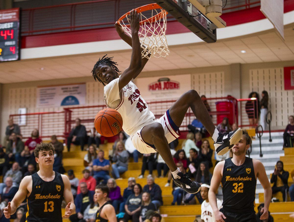 IUSB's Dejon Barney (31) holds on after a dunk during the IUSB vs. Manchester men’s basketball game Thursday, Oct. 27, 2022 at the Student Activities Center on campus at IUSB.  (Photo by Michael Caterina/Indiana University South Bend)